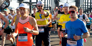 Mine over matter:Sydney Marathon runners,some in hi-vis,on the Harbour Bridge.