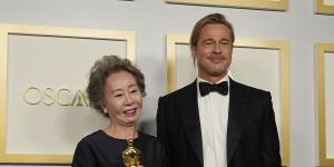 Best actress in a supporting role winner Yuh-Jung Youn poses in the press room with Brad Pitt.