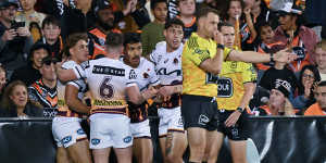 Broncos players celebrate a try during the round eight NRL match against Wests Tigers in Sydney. 