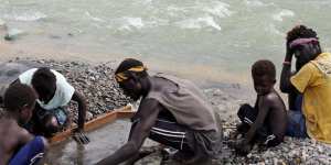 A family panning gold in the polluted Jaba river flowing from Panguna copper mine.