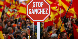 Demonstrators hold banners and Spanish flags during a protest in Madrid,Spain,on Sunday.