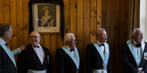 Mason members gather before their monthly dinner at the Kensington Masonic Hall where a portrait of Queen Elizabeth II hangs. 