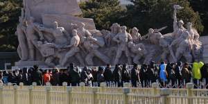 People queue in front of revolutionary statues as they wait to get into Mao Zedong’s mausoleum.