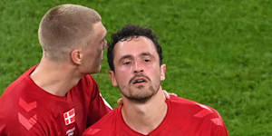 Danish player Rasmus Kristensen consoles Thomas Delaney during the match against Tunisia wearing the subdued Hummel jersey.