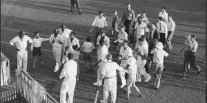 Players move to the gate leading to the dressing pavillion after the Tied Test at the Gabba. Australian Captain Richie Benaud had raced onto the field to shake hands and congratulate West Indies Captain Frank Worrell.