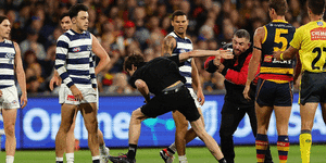 A man is dealt with after running onto Adelaide Oval as Geelong played Adelaide.