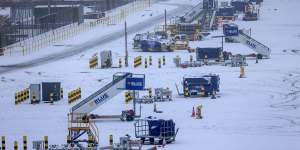 Equipment to be used by aircraft operated by Ryanair Holdings wait on the snow-covered tarmac at London Stansted Airport on Monday.