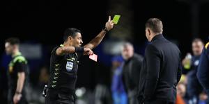 Referee Alireza Faghani shows Mariners assistant coach Danny Schofield a red card.