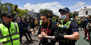 Yemini is moved on by police during a counter-protest against anti-vaxxers,the far-right and fascism in Melbourne in 2021.