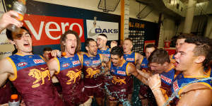 Matt Eagles,second from the left,celebrates with teammates after the Lions beat Hawthorn in 2018. 