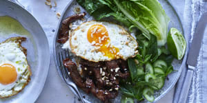 Beef stir-fry with fried egg and peanuts.