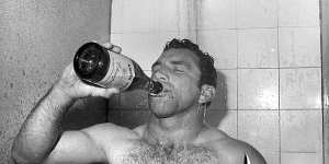 John Sattler enjoys some champagne in the shower after his courageous performance in the 1970 grand final.