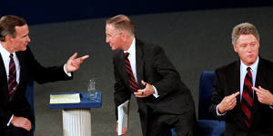 President George H.W. Bush,left,talks with independent candidate Ross Perot as Democratic candidate Bill Clinton stands aside at the end of their second presidential debate in 1992. 