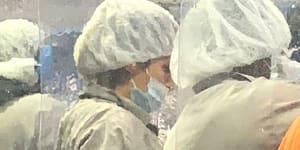 Tyson Foods workers wear protective masks and stand between plastic dividers at the company's poultry processing plant in Camilla,Georgia.