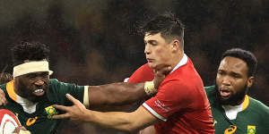 Siya Kolisi of South Africa is tackled by Louis Rees-Zammit.