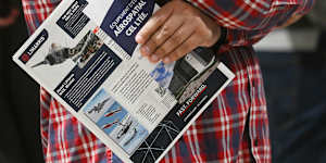 A jobseeker holds an L3Harris flyer at a career in Montreal,Quebec,Canada,this month. Reported say Peter Williams was the general manager of L3Harris subsidiary Trenchant until August this year.