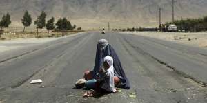 Afghanistan is falling into Taliban hands again. Here an Afghan woman begs for money on the Bagram-Kabul highway,north of Kabul.
