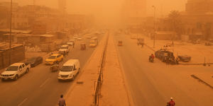 People navigate a street during a sandstorm in Baghdad this year.