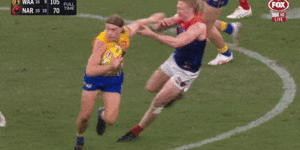 Harley Reid fends off Melbourne opponents Clayton Oliver and Christian Petracca.