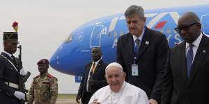 Pope Francis in a wheelchair is flanked by Congolese Prime Minister Sama Lukonde,centre right,as he arrives in Kinshasa,Democratic Republic of the Congo,in January.