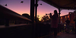 Bugler Sarah Brown aged 23yrs plays The Last Post from the balcony of The Royal Hotel in Leichhardt to a small group of people at dawn on ANZAC Day.