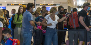 Put it on or leave it off? Passengers at the departure lounge of Miami International Airport in Florida.