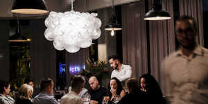 A cloud-shaped chandelier casts bubbly shadows on the ceiling.