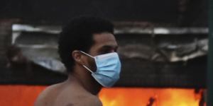 A man runs near a burning building after a night of unrest in downtown Minneapolis.