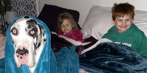 Rebekah Sawyer’s children,Wyatt and Emma,and dog Paige,try to stay warm during the Texas power blackout.