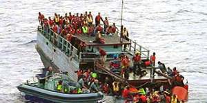 Australian navy personnel rescue asylum-seekers from a sinking boat off Christmas Island.