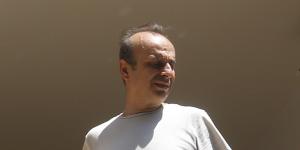 A man looks out from the collapsed facade of a building in downtown Beirut.