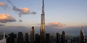 Desert miracle:Dubai skyline with the moon on the tip of Burj Khalifa,the world’s tallest building.