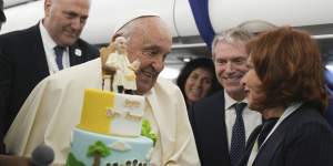 Pope Francis is presented with a cake by Valentina Alazraki,correspondent for TeleVisa Univision,to celebrate his birthday,on a flight back from Ajaccio,Corsica.