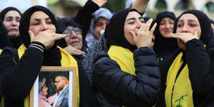 Mourners at a funeral in Lebanon with a photograph believed to be of Australian man Ibrahim Bazzi and his wife Shorouq Hammoud.