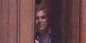 Prince Andrew peering out from behind the door of Epstein’s Manhattan mansion in 2010.