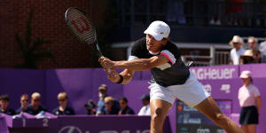 Alex de Minaur returns the ball to Carlos Alcaraz.