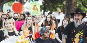 Attendees at the No More:National Rally Against Violence walked past areas fenced off due to asbestos contamination in Belmore Park,Haymarket. 