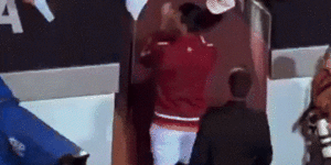 Novak Djokovic is struck on the head by a water bottle.