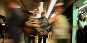 Commuters board a metro train at Victoria Cross station in North Sydney.