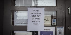A sign posted to the door of a pharmacy in Carlton informs customers it has sold out of rapid antigen tests.