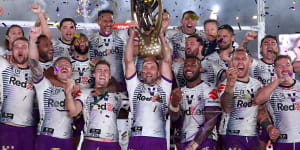 The Storm celebrate with the premiership trophy at ANZ Stadium on Sunday.