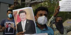 An Indian man holds a photograph of Chinese President Xi Jinping during a protest against China in Ahmedabad,India,this week.