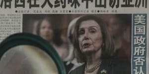 A Beijing resident reads a newspaper headline reporting on US House Speaker Nancy Pelosi’s Asia visit.