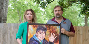 Minnesota parents Melissa and Jim Crowley hold a portrait of their son Alex Crowley,who attended a school close to a 3M facility and died of brain cancer.
