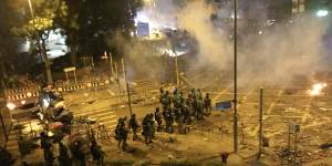 Riot police storm road in front of Polytechnic University before dawn. 