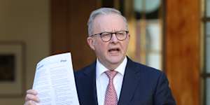 Prime Minister Anthony Albanese holds up a copy of the national fuel plan at Monday’s press conference.