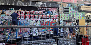 Workers remove the ‘She Matters’ mural in Hosier Lane,Melbourne
