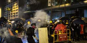 Demonstrators are shrouded in a cloud of tear gas outside the North Point Police Station in Hong Kong on Monday.