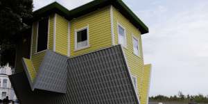A man walks past the “Upside Down House” in Clacton-on-Sea.