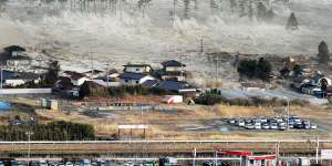 Waves from the March 11,2011 tsunami hit residences in Natori,in Japan’s Miyagi prefecture.